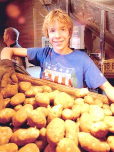 Happy Maine Teenager Working In Potato House.