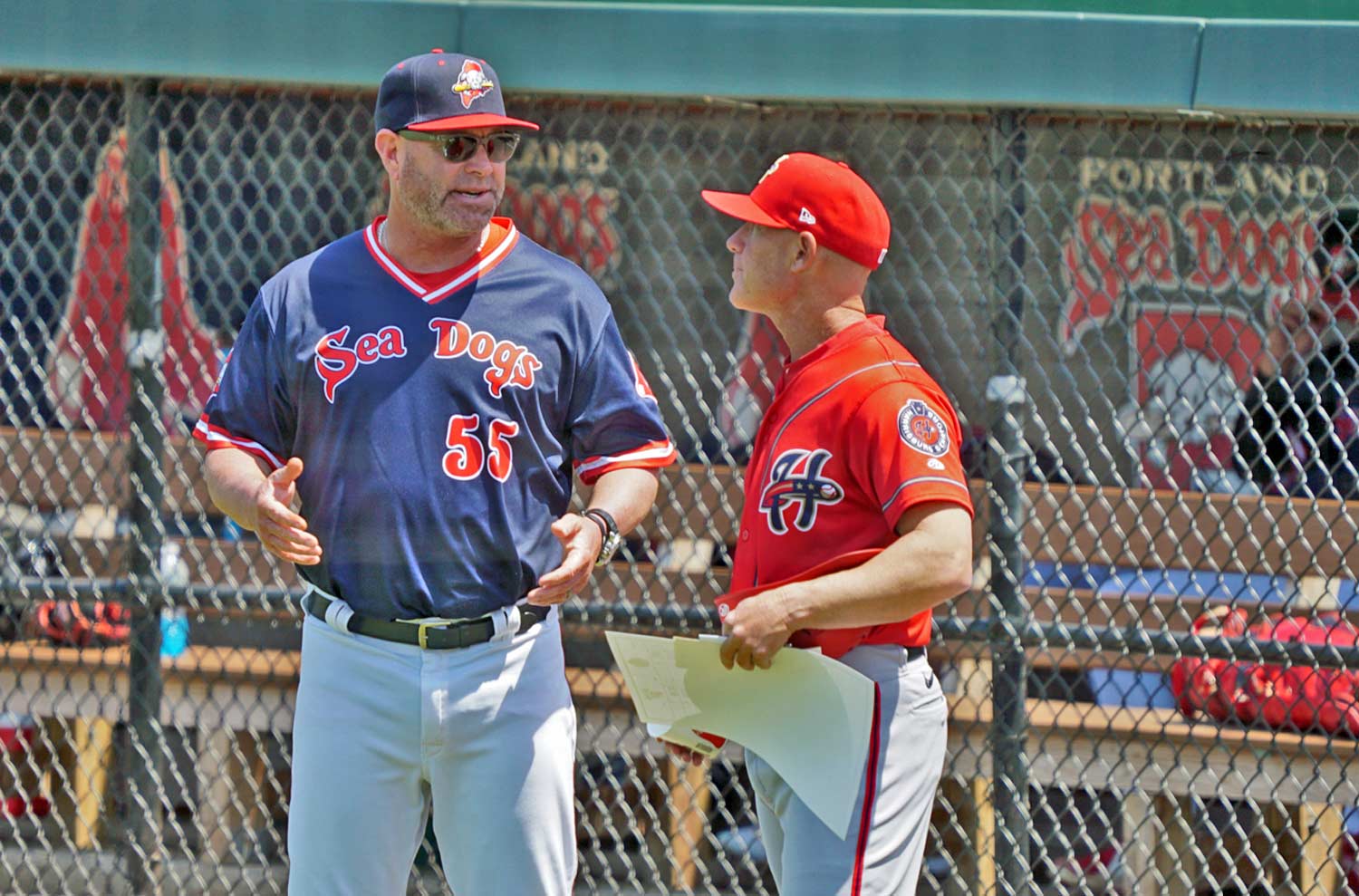 Baseball Team Coaches Confer And Shoot The Breeze Before The Game Gets Underway.